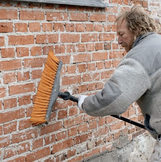 Putsa vägg: Väggen borstas ren med en grov borste eller kvast