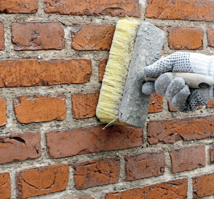 Putsa vägg: Väggen fuktas med borsten