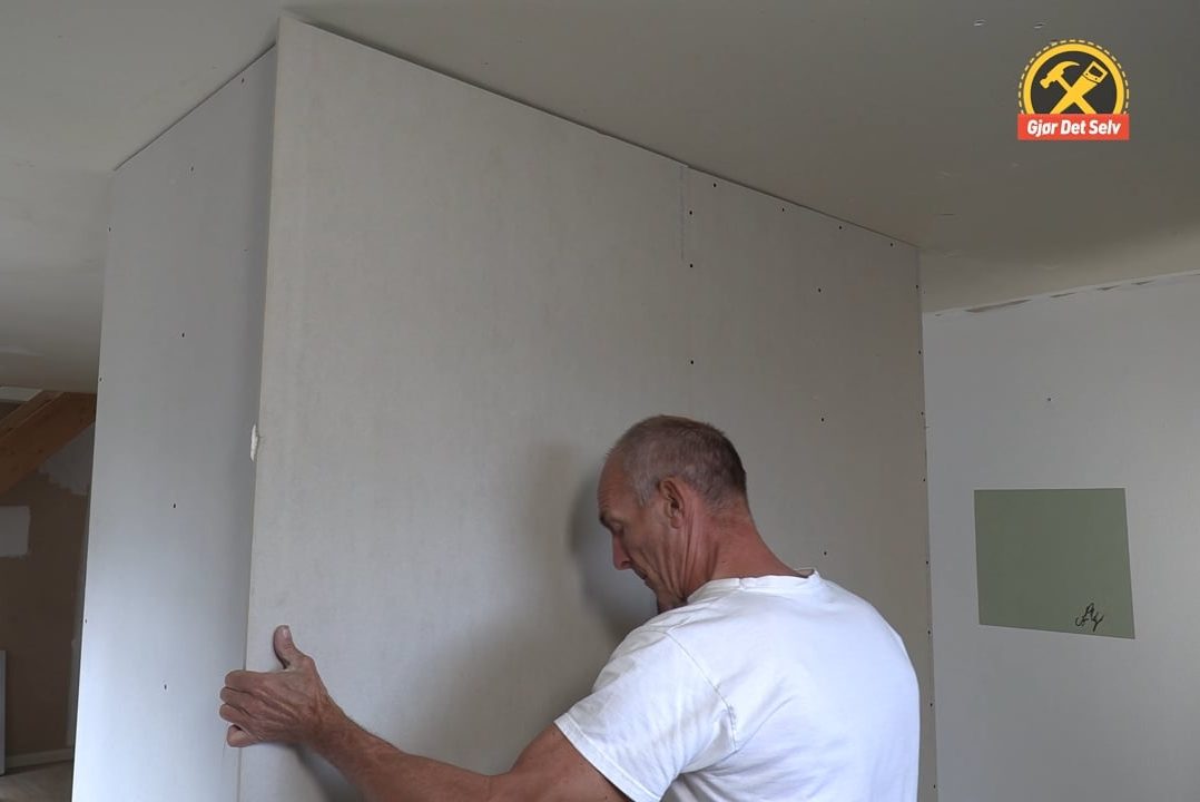Løft gipsplaten helt tett opp mot taket
