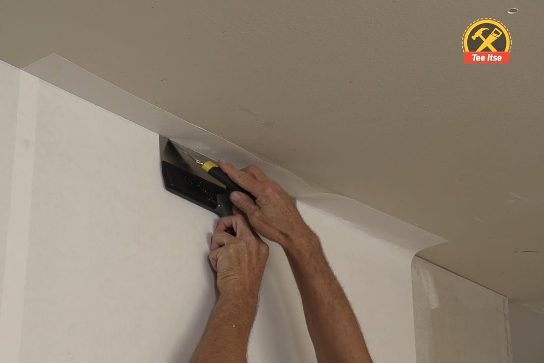 Leikkaa lasikuitutapettia lastalla ja veitsellä