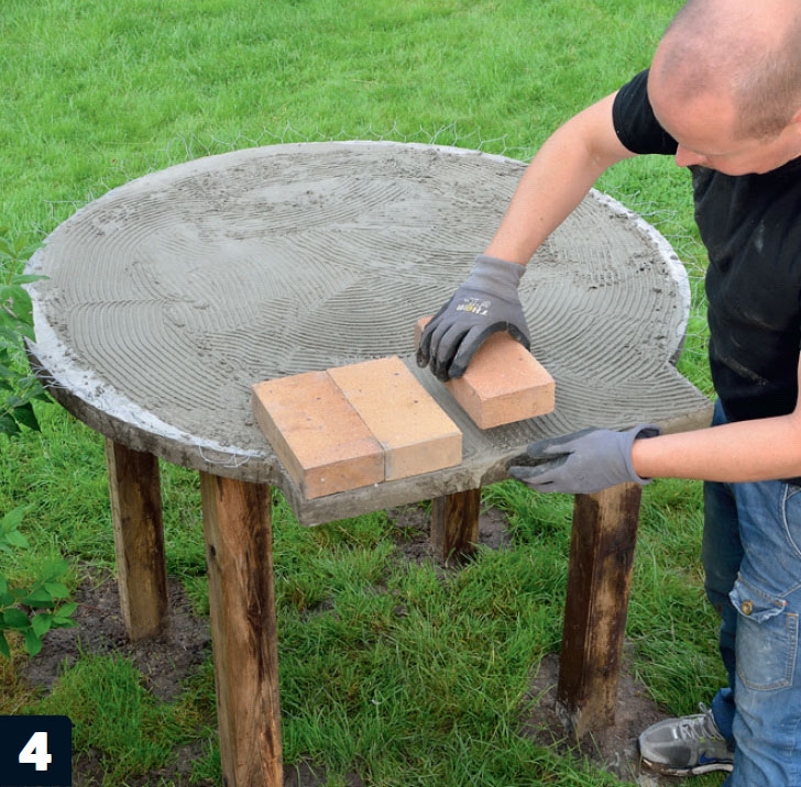 De ildfaste steinene til murt pizzaovn legges i mørtelen