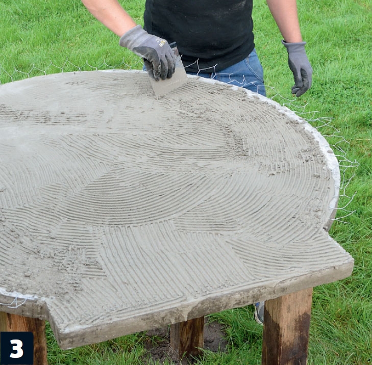 Hönsnätet läggs på skivan och bruket fördelas på murad pizzaugn