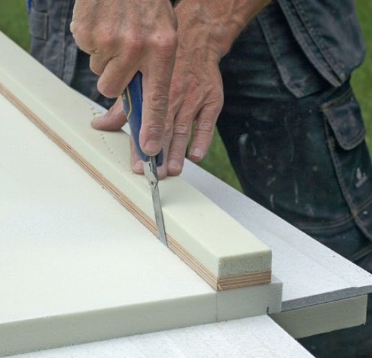 Varmveggsplater: Isolasjonen bak på platen skjæres til