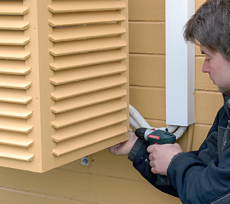 Varmepumpeskjuler sættes på plads, så varmepumpen dækkes