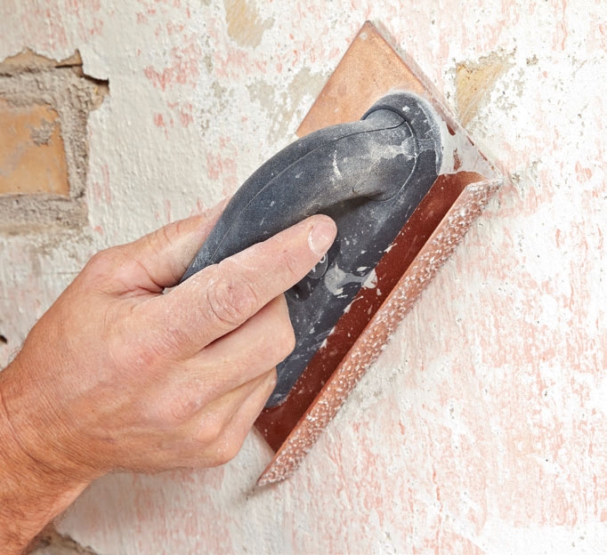 Isolere kjellervegg: Fjern løs puss, og slip veggen