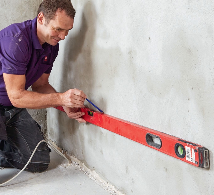 Isolere kjellervegg: Strek opp veggen ved hjelp av et vater