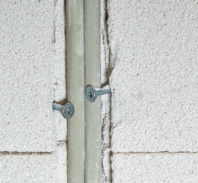 Isolera källare: Kablarna hålls på plats med ett par skruvar