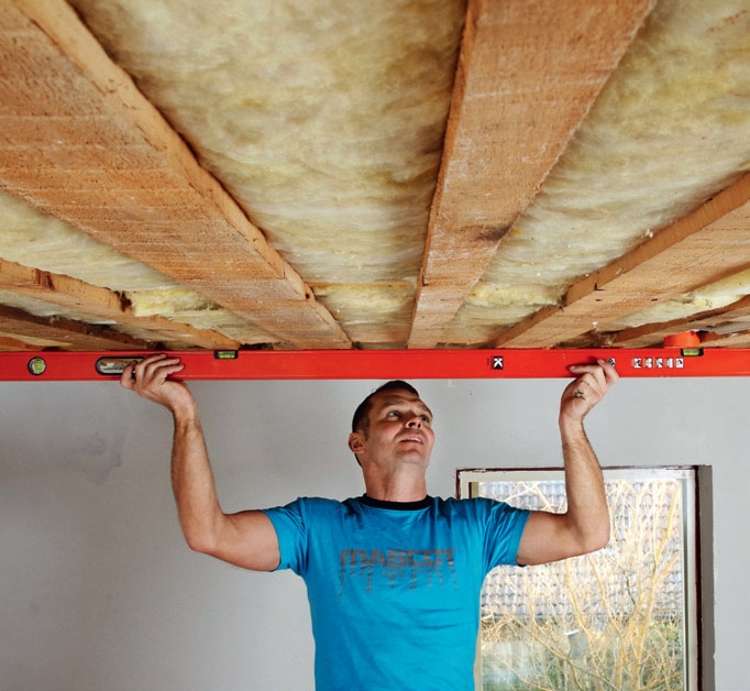Opsætning af gipsloft: Den gamle forskalling tjekkes med et langt vaterpas