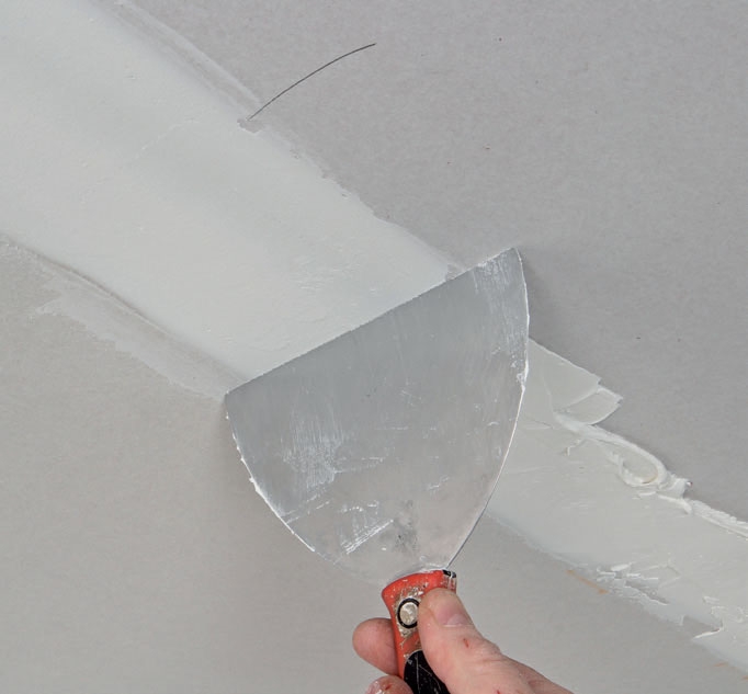 Kipsilevy kattoon: Poista ylimääräinen tasoite leveällä ja jäykällä lastalla