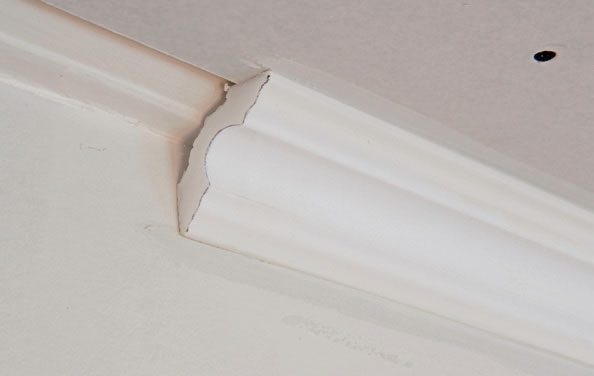 Kipsilevy kattoon: Se kiinnitetään stukkoliimalla. Paina reunus paikalleen katon ja seinän rajalle