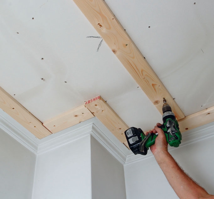 Gipsplader til loft: Hold et bræt til mærket, og skru det fast til loftet