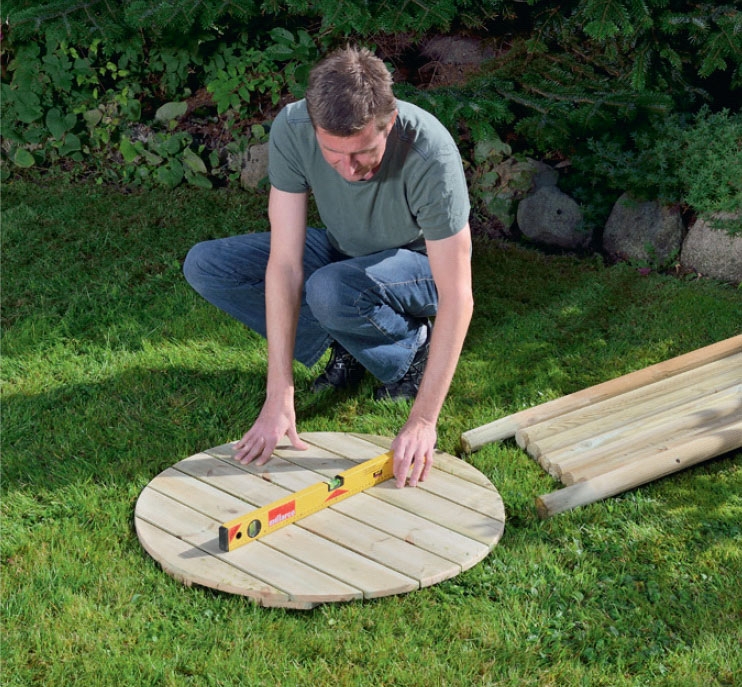 Der tjekkes med vaterpas, om underlaget til udendørs bruseren er jævn