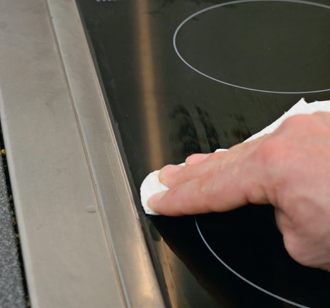 Glattevæsken tørkes forsiktig av kokeplaten og benkeplaten
