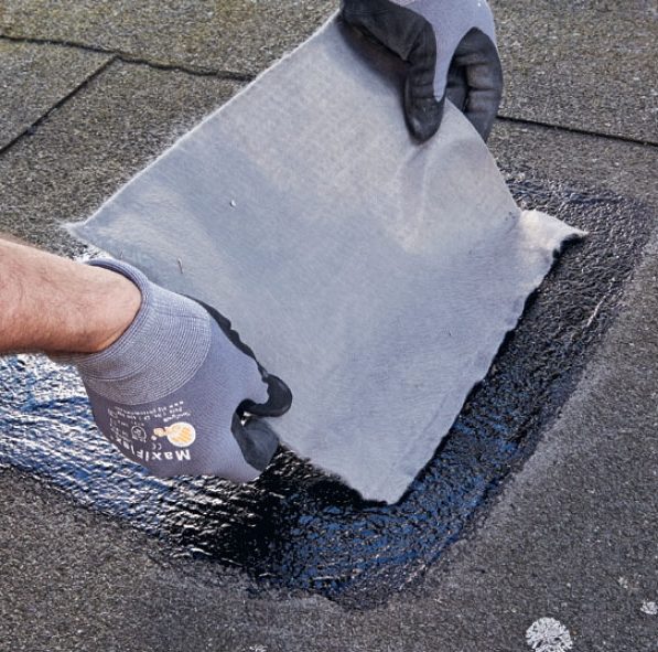 Sprickor och hål i takpapp: Reparationsduken läggs i takkitt