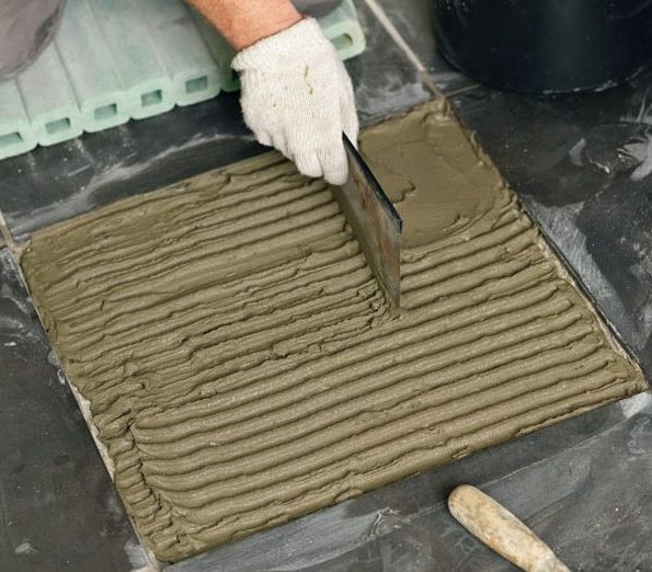 Sprekker i fliser: En ny flis trykkes ned i flislim