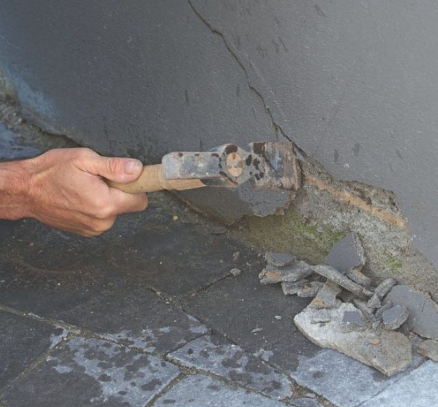 Reparation af revner i væg: Al løs puds bankes af