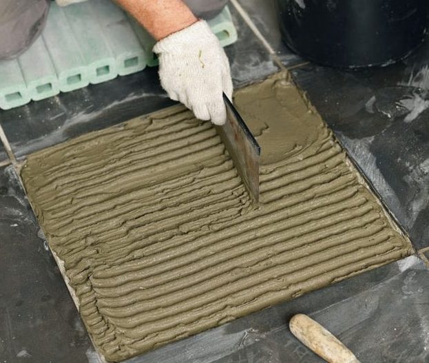 Reparation af revner i væg: Den ny flise trykkes ned i fliseklæber