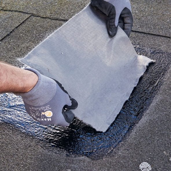 Revner i tagpap: Reparationsdugen lægges ned i et lag tjæretagmasse