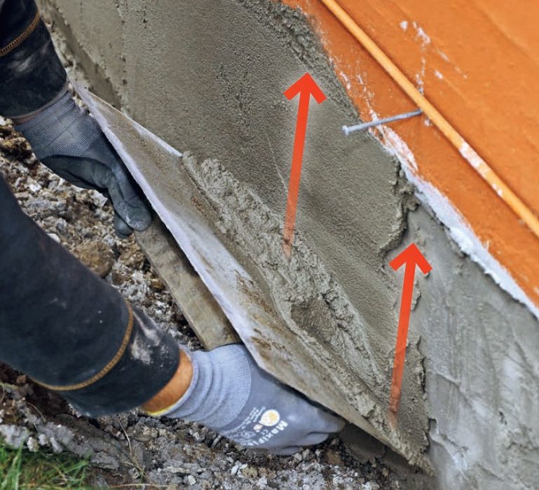 Pudsning af sokkel: Træk mørtlen på med et stålbræt