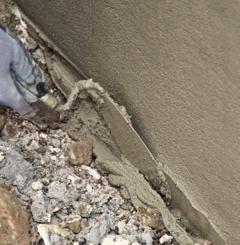 Pudsning af sokkel: Forneden rettes laget af med en murske