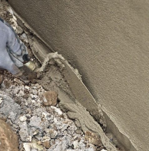 Putsa sockel: Nederst avjämnas skiktet med en murslev