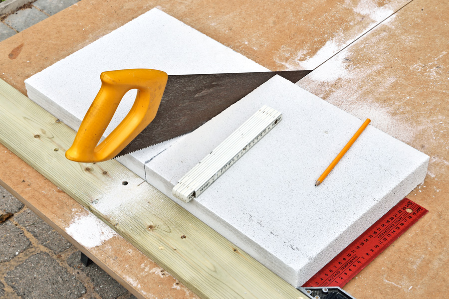 Et bord skrudd fast på platen, vinkelrett på sagsporet, styrer emnet som skal sages over.