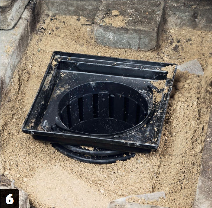 Sivebrønd med sten i flisebelægning