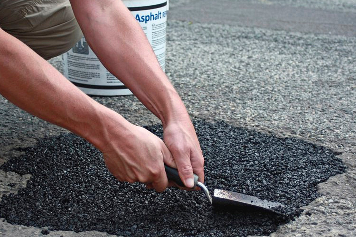 Korjausasfaltti painetaan kuopan pohjalle ja tiivistetään.