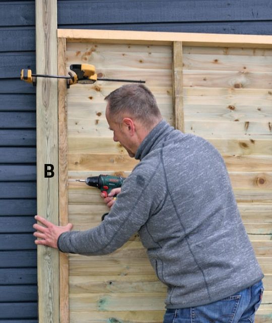 Hjørnestolpen skrues fast til bagrammen på skuret