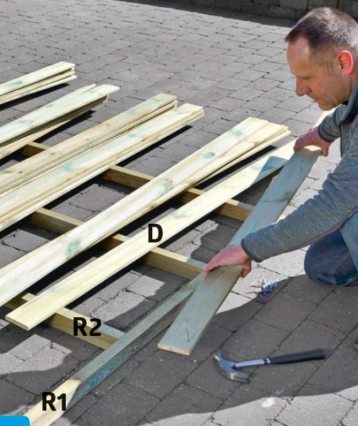 Klinkbrädor monteras på stommarna på förråd