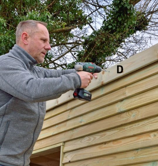 De lodräta intäckningarna skruvas fast längs sidorna på förråd