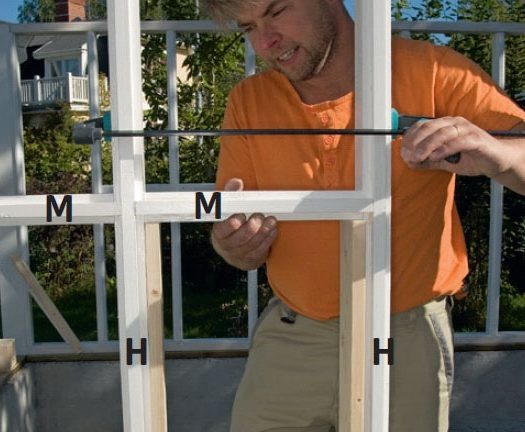 De vannrette sprossene i orangeri settes mellom stolpene