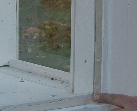 Kitt slätas ut med ett finger i ruta i orangeri