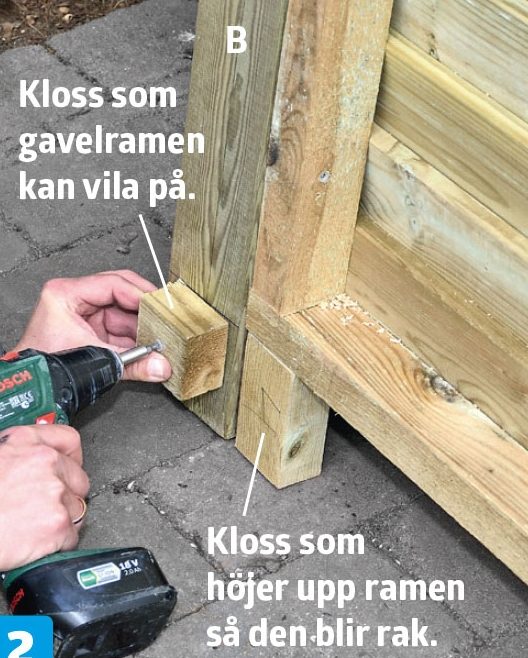 En bit läkt skruvas fast i stolpen på förråd