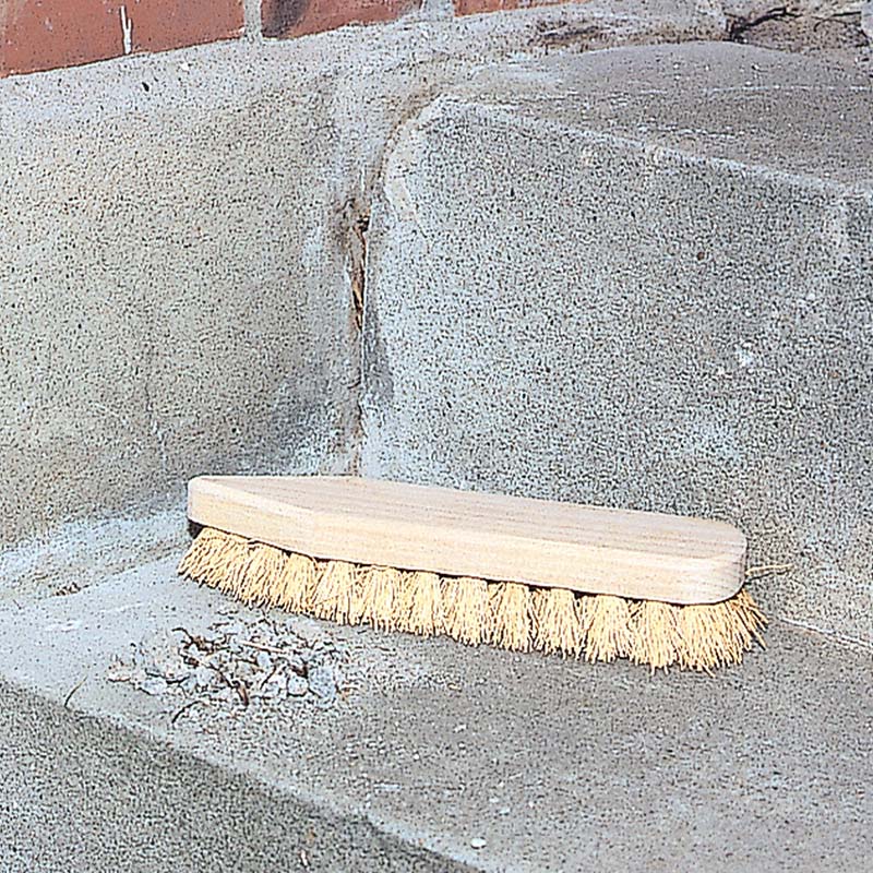 Laga betongtrappa: Damm och lös betong avlägsnas med en kraftig borste