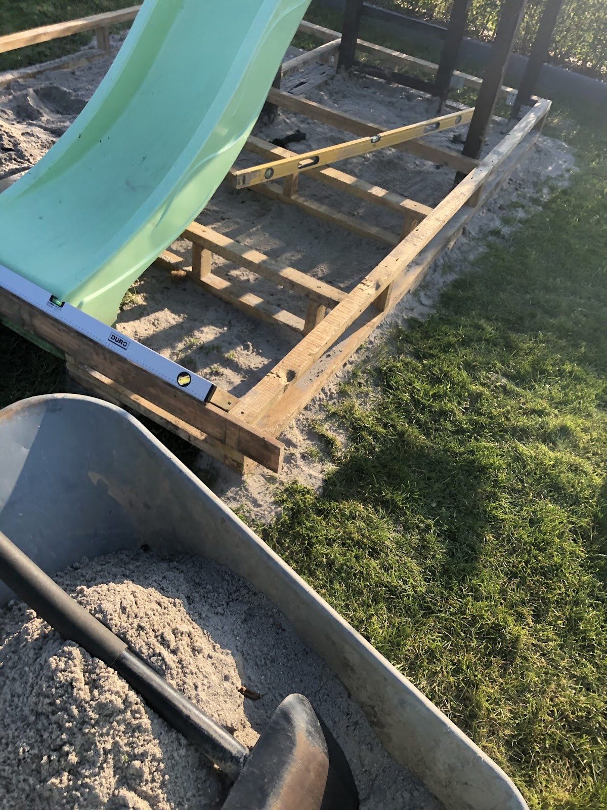 Skjult sandkasse omkring gyngestativ