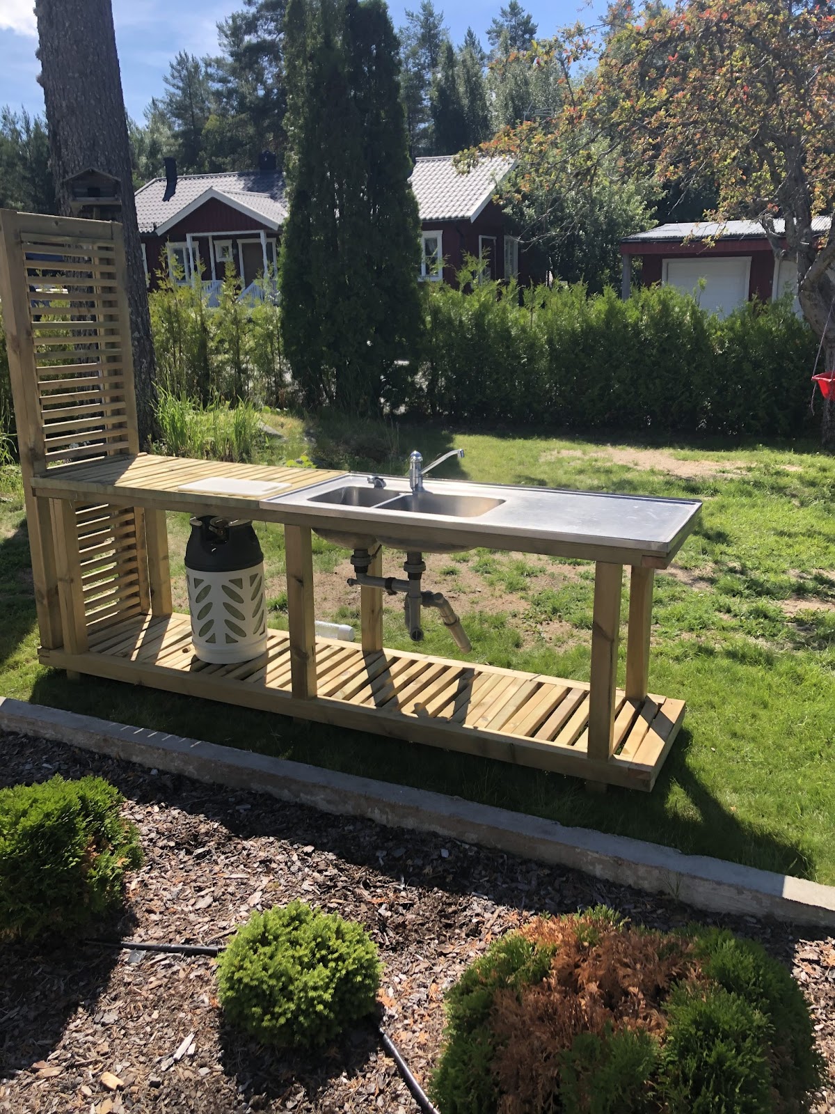 Terrasse og et stort udendørsbord af en stor gran