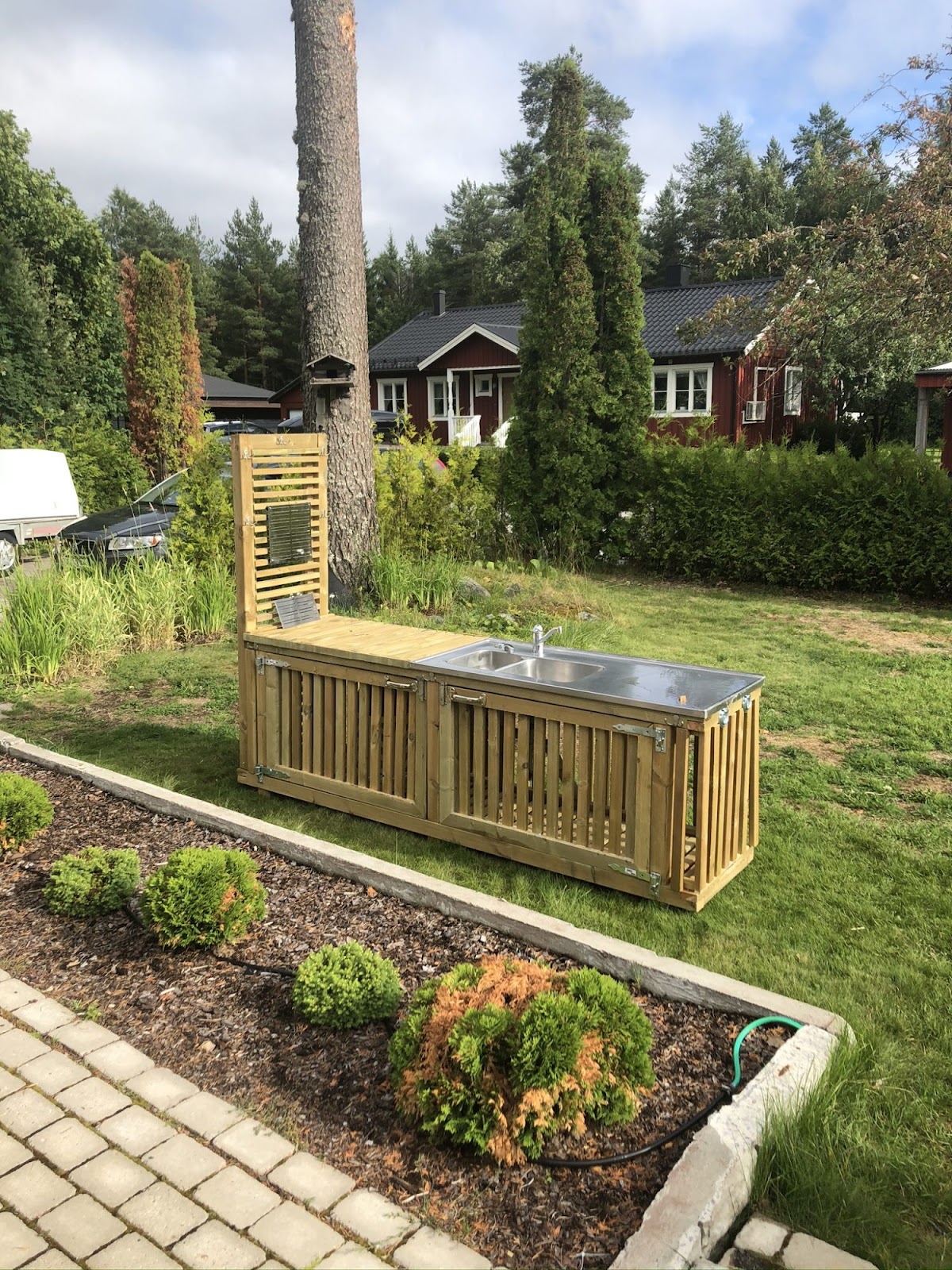 Terrasse og et stort udendørsbord af en stor gran