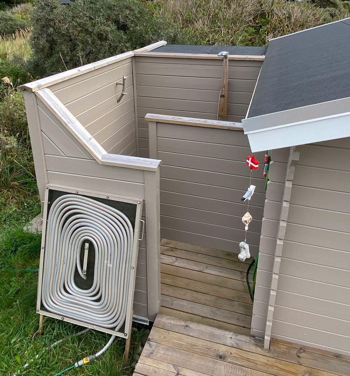 Kierrätysmateriaaleista rakennettu ulkosuihku aurinkolämmitteisellä vedellä