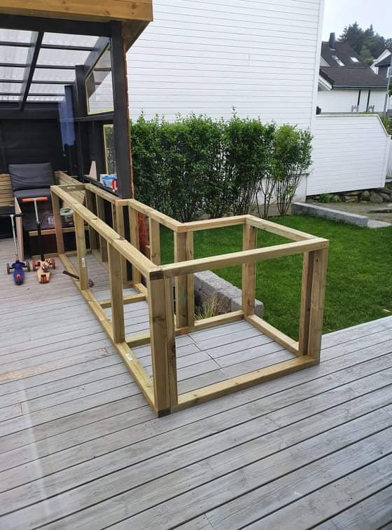 Hagestue med sofa og utekjøkken