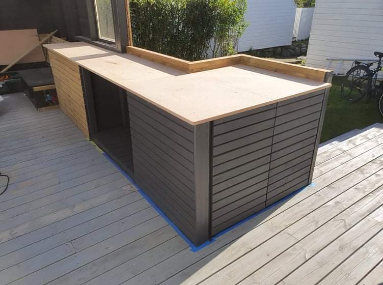 Hagestue med sofa og utekjøkken