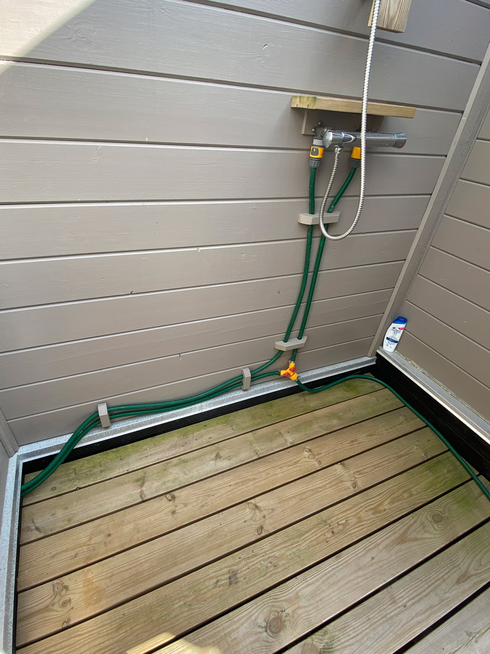 Utendørs dusj med solvarmet vann og resirkulert materiale