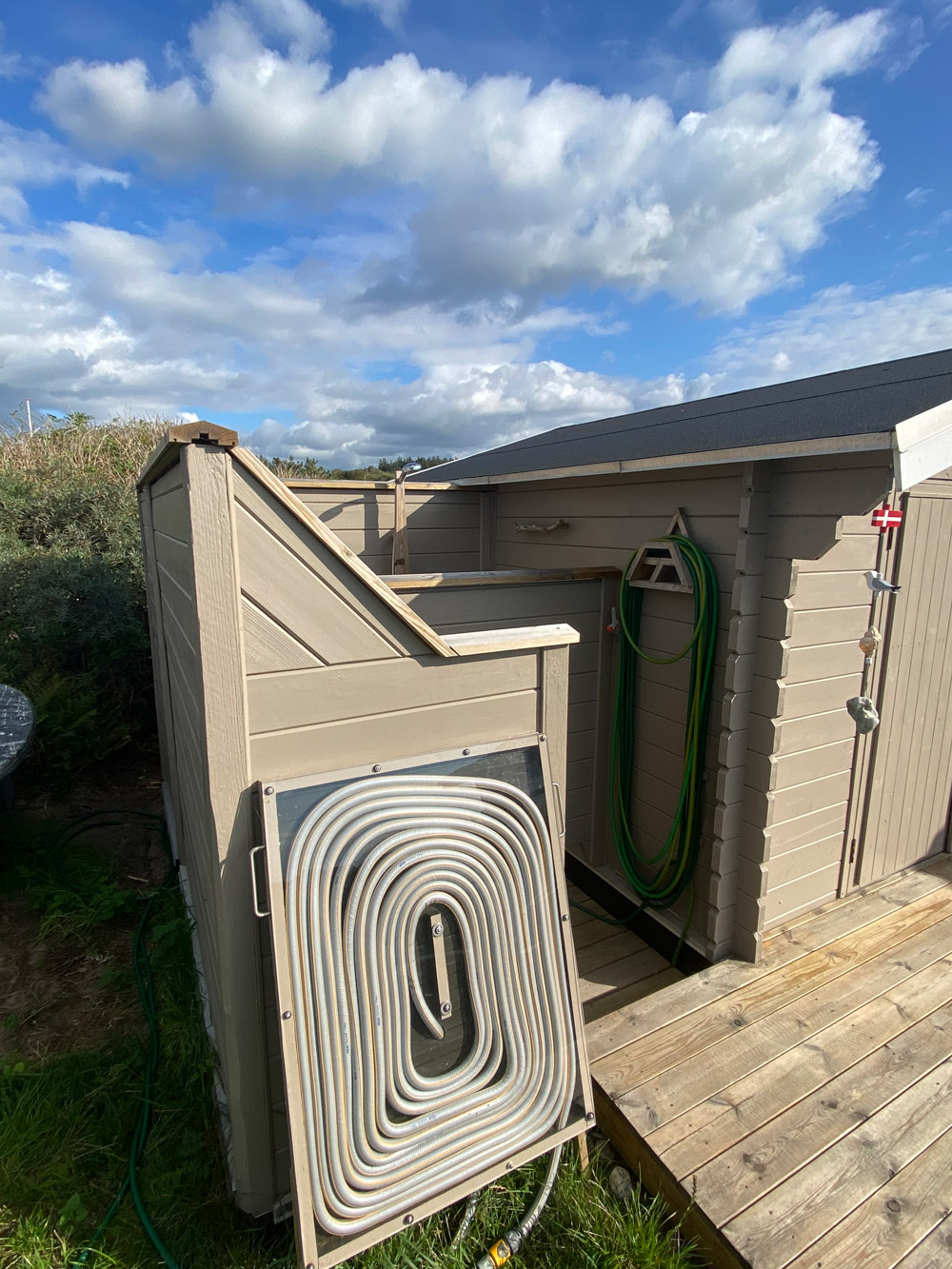 Utendørs dusj med solvarmet vann og resirkulert materiale