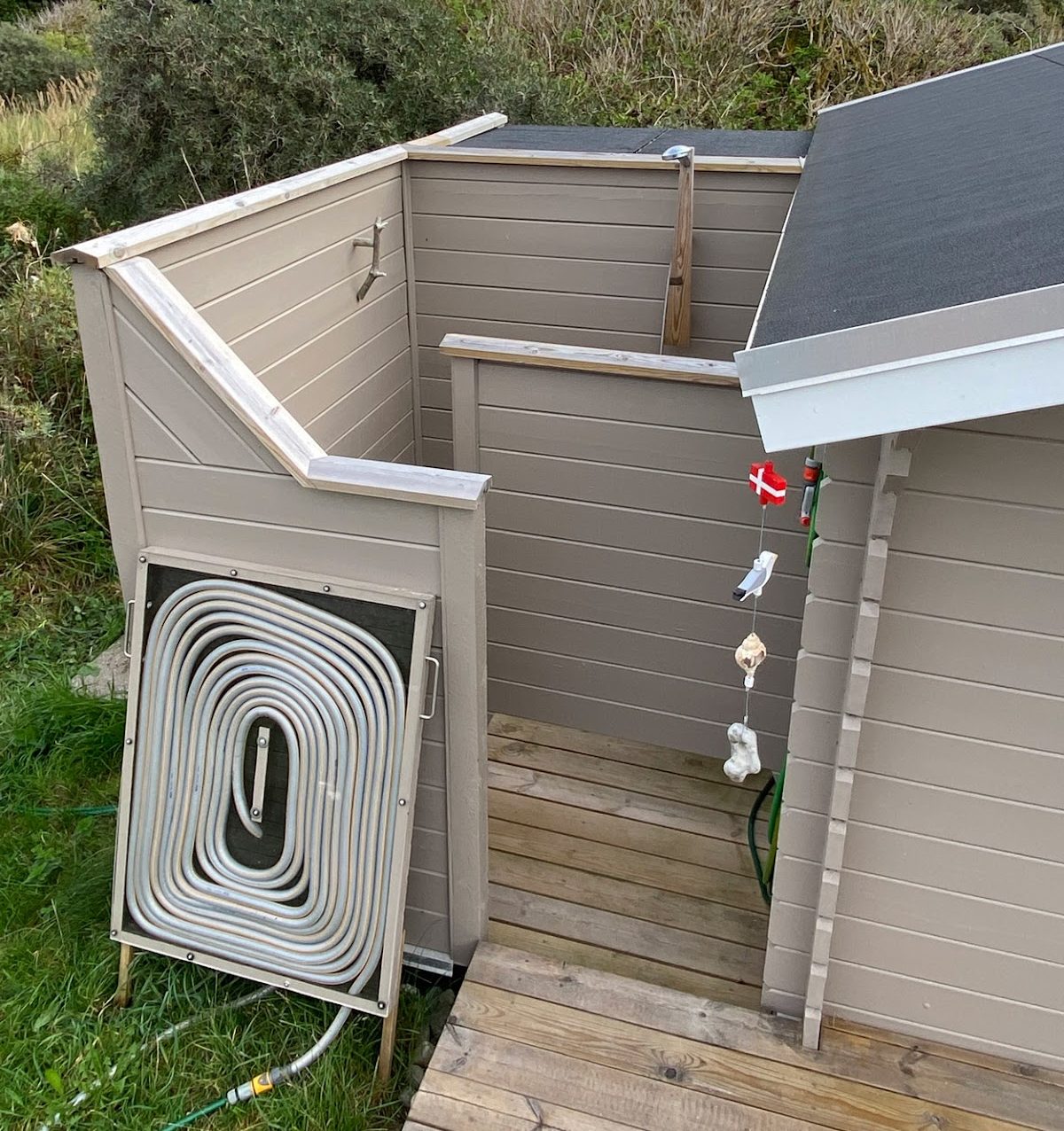 Utendørs dusj med solvarmet vann og resirkulert materiale