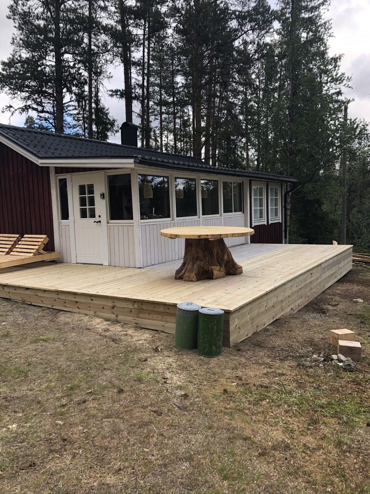 Terrasse og et stort utebord av en stor gran