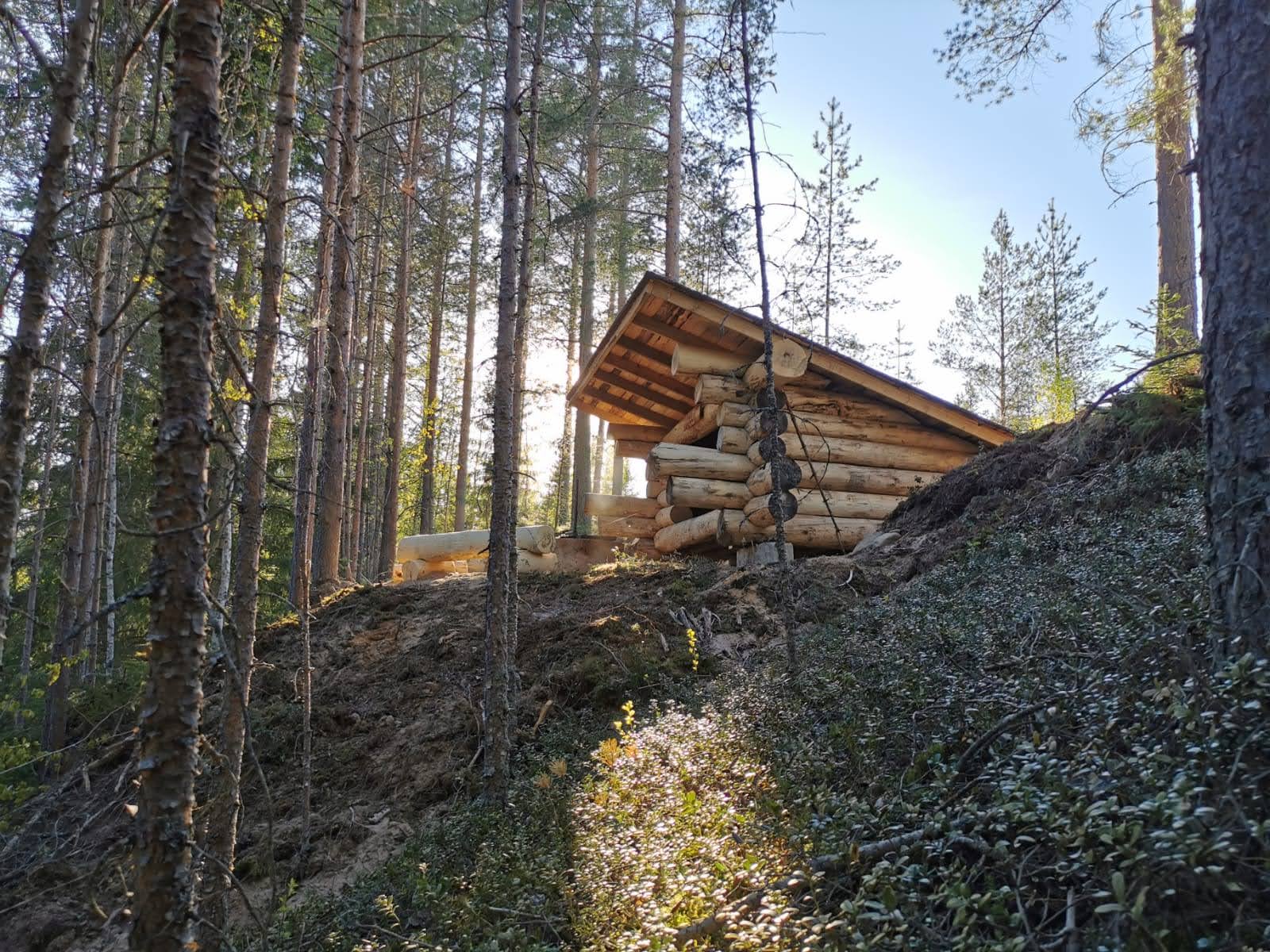 Rustikt vindskydd av tjocka stammar