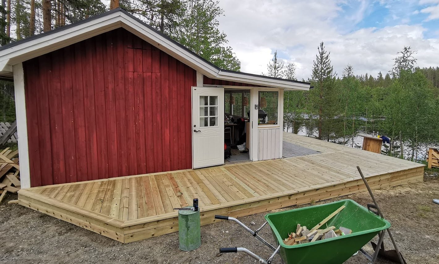 Terrass och en stor utebänk av en stor gran