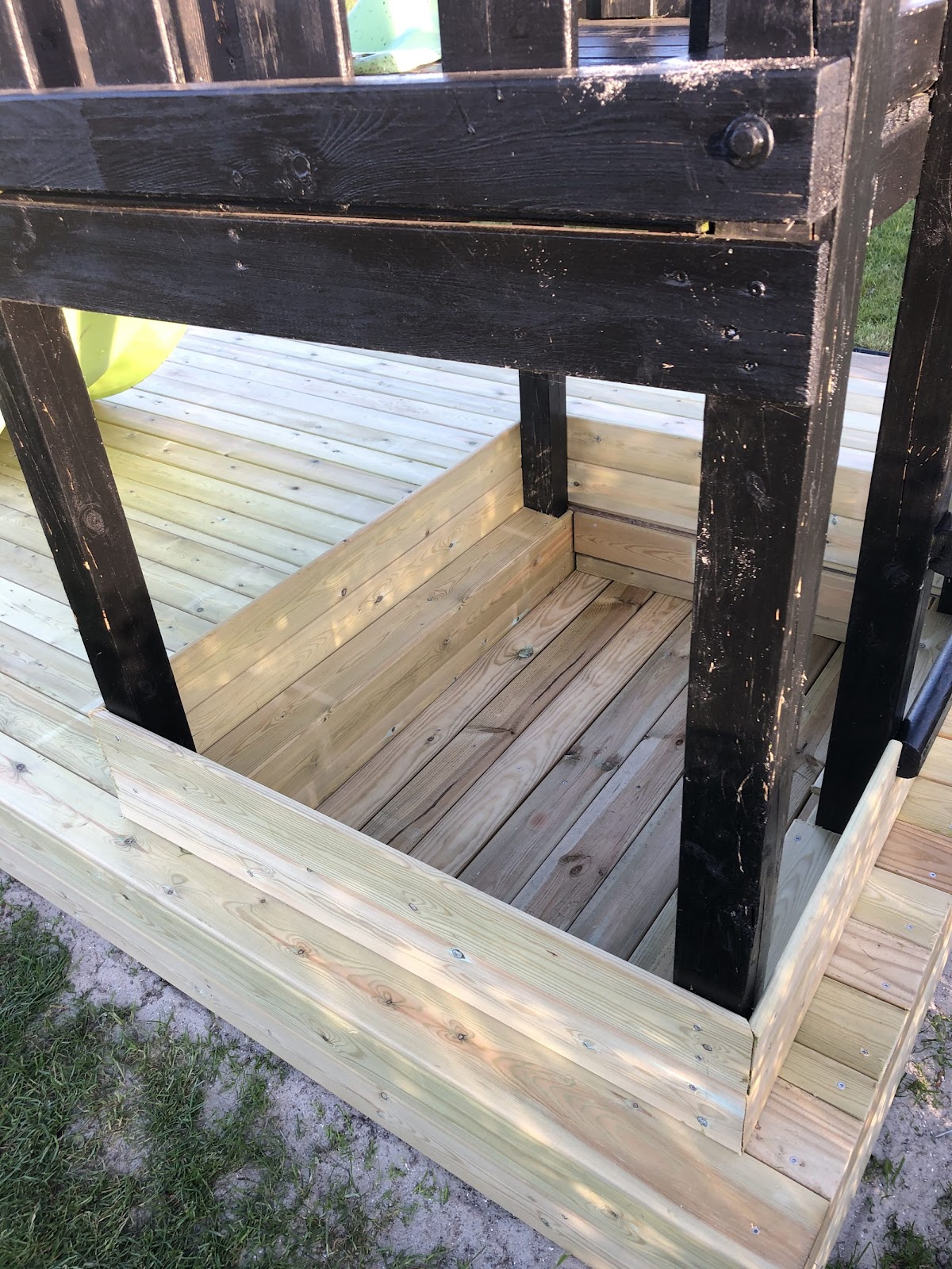 Dold sandlåda runt gungställning