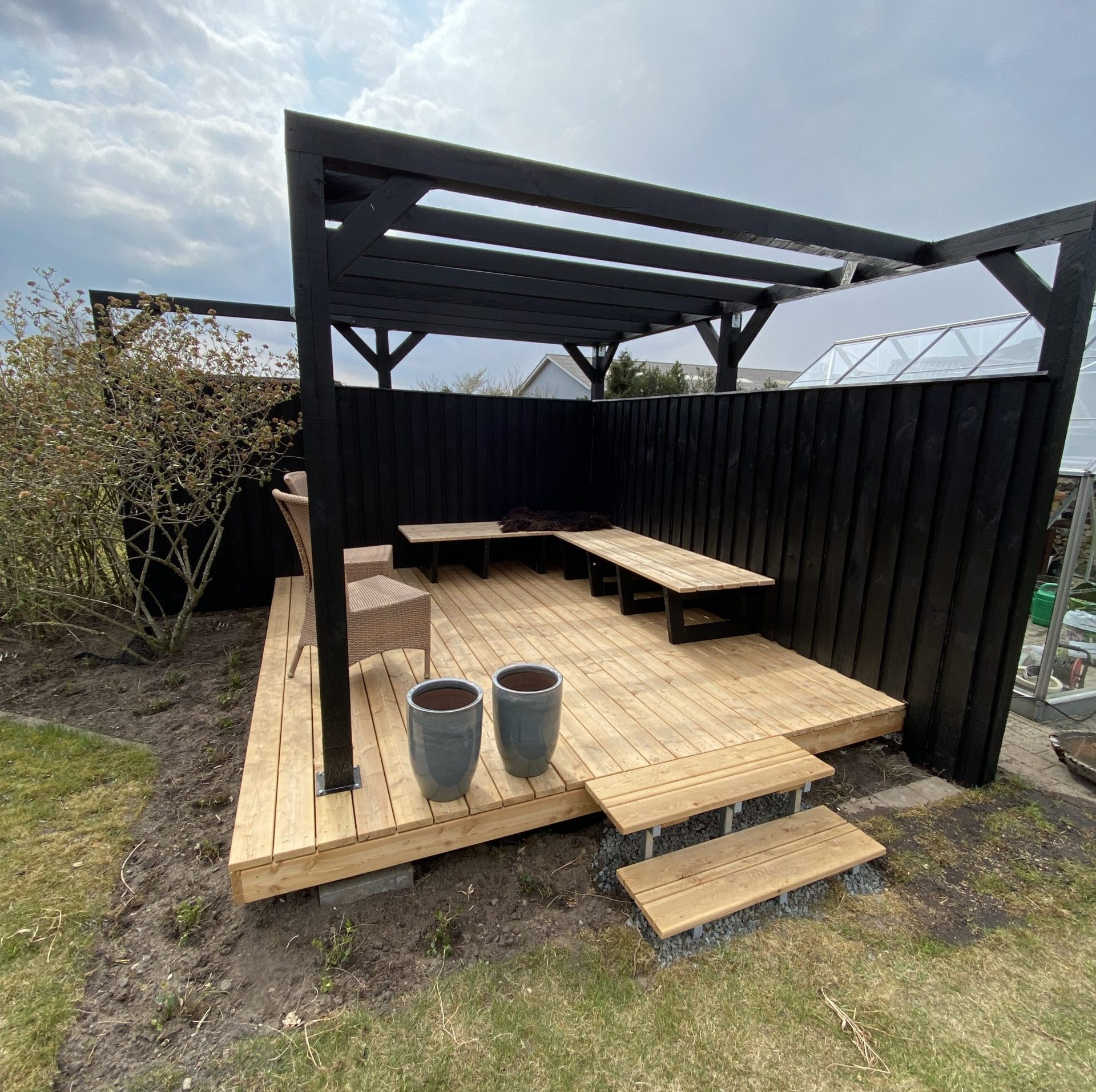 Terrass med pergola och platsbyggda bänkar