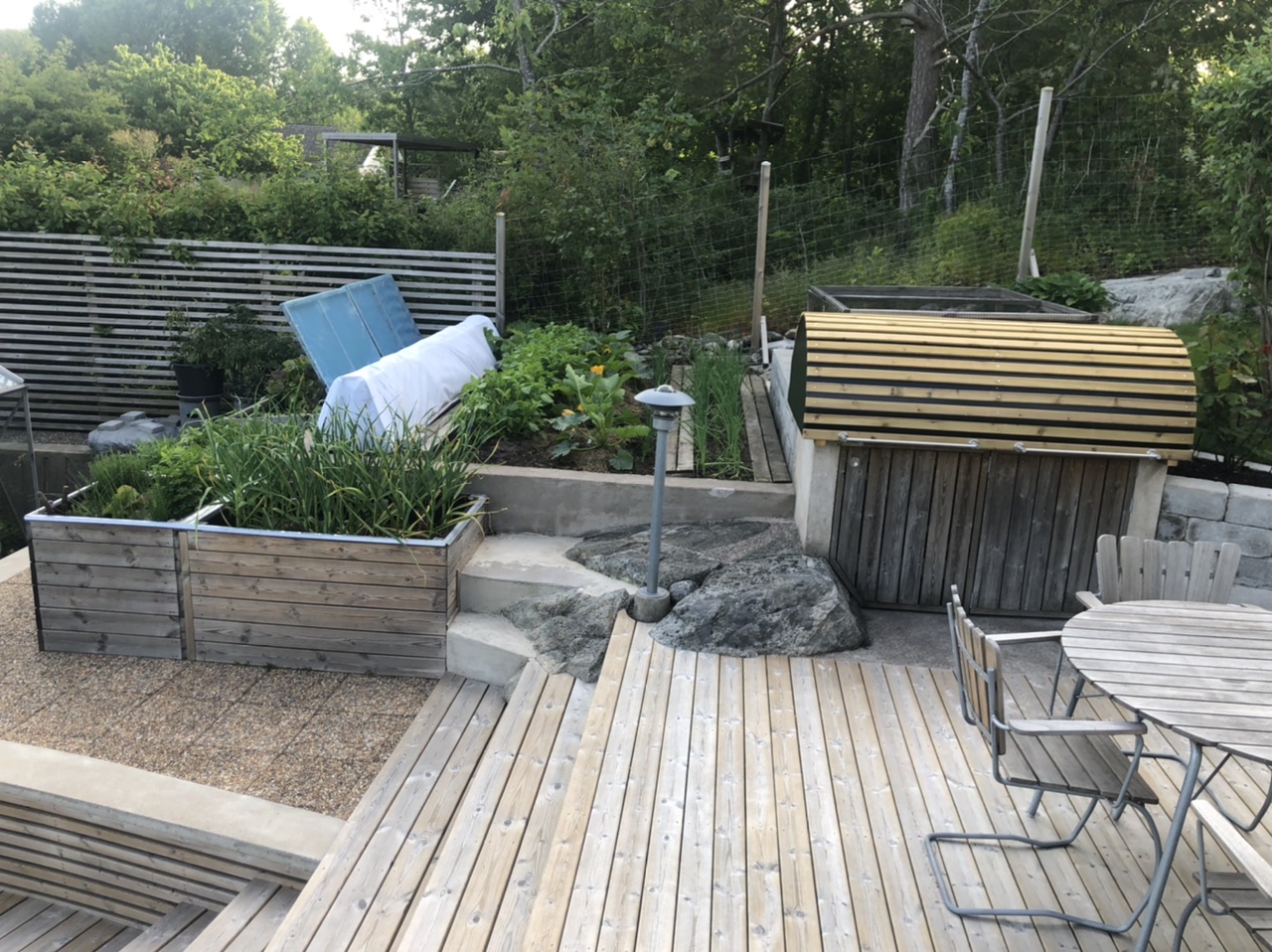 Träterrass med flera nivåer i trädgårdshörnet